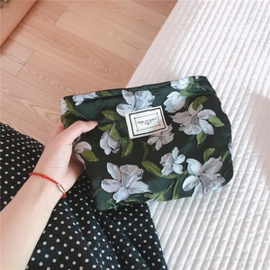 Detail of dark green floral canvas cosmetic bag with Time to Party label and zipper