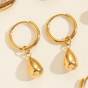 Detail of 18K gold-plated titanium earrings featuring polished water drop pendant dangles