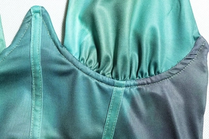 Detail of gradient satin bodice with corset boning and pleated cup stitching details