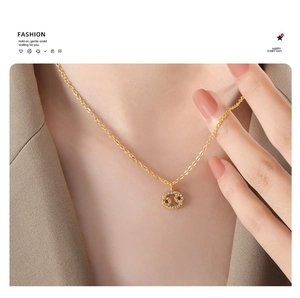 Detailed close-up of a gold Cancer zodiac necklace with sparkling rhinestones on a model