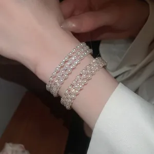 French vintage multi-layer pearl bracelet with sparkling diamonds on female wrist