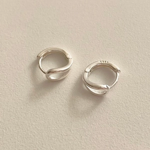 Macro shot of silver S925 sterling silver hoop earrings with twisted knot design