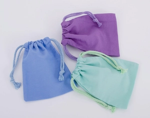 Close-up of small cotton drawstring storage bags in blue, purple, and mint green