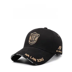 Detail of classic black cotton baseball cap with gold 3D embroidery and shield patch