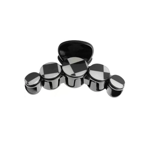 Minimalist black and white checkerboard metal hair clip with five circular design elements