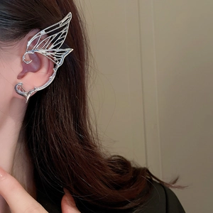 Close-up of a silver butterfly ear cuff featuring intricate hollow metal wing patterns