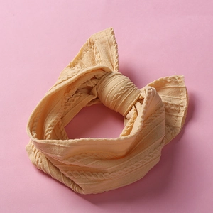 Detailed view of yellow jacquard knitted baby headband with a decorative bow knot