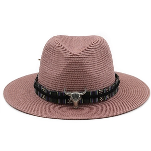 Pink straw cowboy hat featuring a tribal band and silver bull head ornament on front