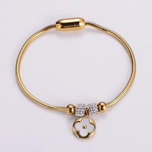 Gold snake chain bracelet with clover pendant and white shell inlay detail