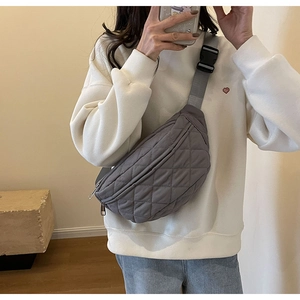 Gray quilted crossbody chest bag featuring adjustable strap and secure buckle closure