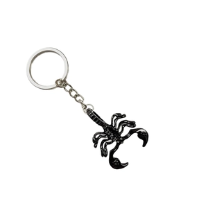 Creative black scorpion metal keychain with silver ring on white background