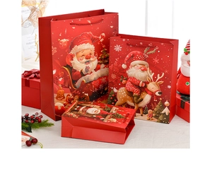 Detailed view of red Christmas gift bags with Santa and reindeer motifs in three sizes