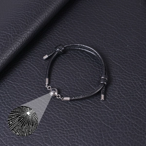 Macro detail of black projection bracelet with 100 languages of I Love You text