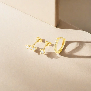 Detail of 3-piece gold S925 silver stud and huggie hoop earrings with white zircon stones