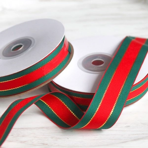 Detailed view of red and green striped Christmas ribbon rolls with gold metallic edges
