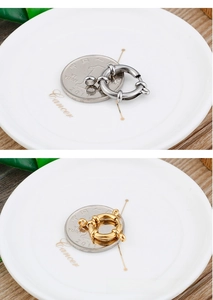 Macro detail of gold and silver stainless steel spring clasps on a white ceramic plate
