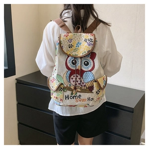 Detailed view of owl embroidery on beige linen backpack with Home Sweet Home text