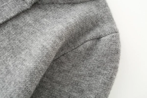 Dettaglio del morbido tessuto a maglia grigio mélange con trama fine e cuciture pregiate