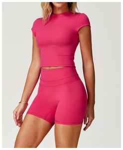 Detail of a vibrant rose red slim-fit yoga short sleeve and high waist sports shorts