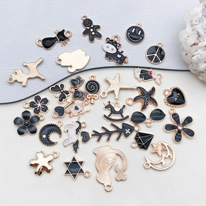 Collection of black and gold enamel charms in shapes like cat moon and star for DIY jewelry
