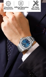 Detail of luxury men's steel watch with diamond bezel and blue dial on suit sleeve