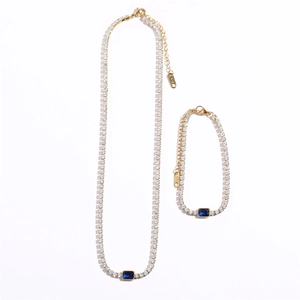 Detailed view of emerald blue stone necklace and bracelet set in 18K gold plated steel