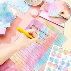 Pastel watercolor stationery set with envelopes and stickers on a pink background