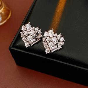 Macro shot of silver heart earrings with sparkling cubic zirconia on a black leather box