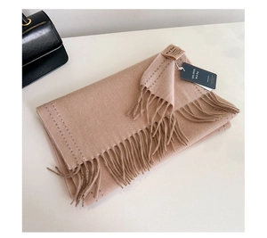 Close-up of 100% Australian wool scarf in camel with soft knitted texture and long tassels