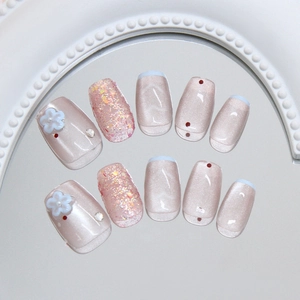 Pink cat eye press-on nails with 3D white flowers and pearls on a mirror background