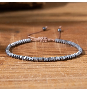 Detail of beaded hematite bracelet with adjustable brown cord and sliding knot closure