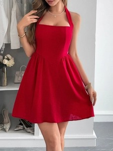 Chic red halter neck mini dress shown on a model in a modern home closet setting