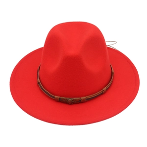 Close-up of red wool felt fedora with brown leather band and bronze skull ornament