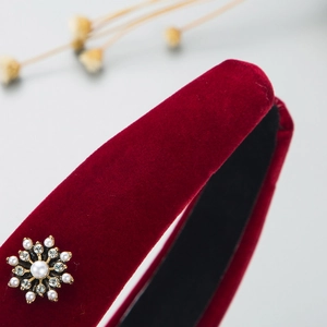 Macro shot of red velvet headband with snowflake pearl and rhinestone embellishments