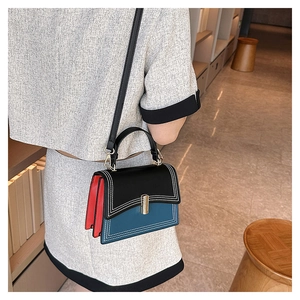 Vue latérale du sac à main en cuir multicolore avec fermoir doré porté par un mannequin