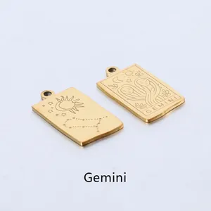 Detail of gold Gemini zodiac rectangle pendants with engraved celestial patterns