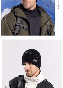Detail of black winter knit beanie with grey mountain pattern and leather logo patch