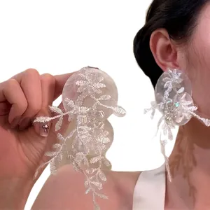 Exaggerated white lace flower drop earrings with shimmering sequins and beads
