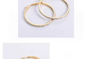 Detailed macro view of large gold hoop earrings with full white crystal inlay
