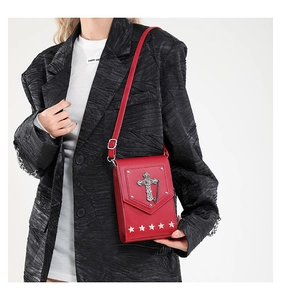Detailed shot of red crossbody bag featuring vintage silver cross and star studs
