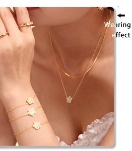 Close-up of double-layer necklace and clover bracelets with pave zircon on model