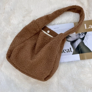 Close-up of brown faux shearling tote bag featuring a secure silver magnetic snap closure