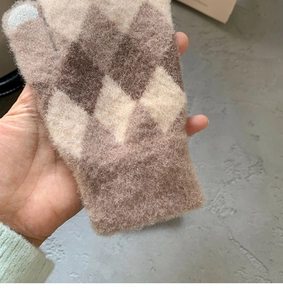 Detailed view of argyle knit wool gloves with warm mohair texture and beige brown pattern