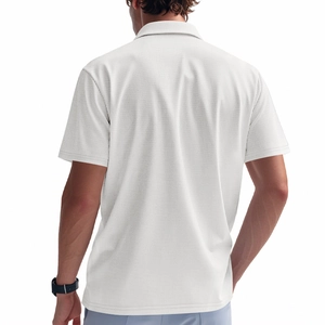 Detalle de polo blanco de punto gofrado que muestra el tejido texturizado y el ajuste de hombro