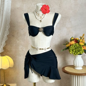 Vue détaillée du haut de bikini noir avec boucle soleil et mini-jupe à volants