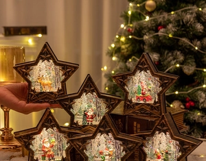 Détail des lanternes à neige de Noël en forme d'étoile avec figurines de Père Noël.
