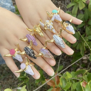Bohemian bull skull rings with colorful synthetic stones shown on fingers in nature