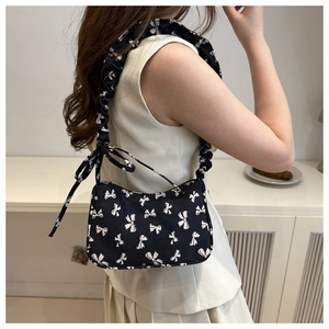 Floral hobo bag with bow pattern and scrunchie drawstring strap shown on a model