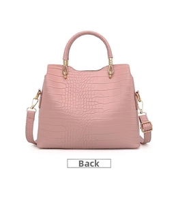 Detailed back view of pink crocodile embossed handbag with golden hardware and long strap