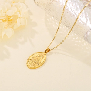 Macro detail of gold oval Mother and Child pendant with embossed relief on link chain